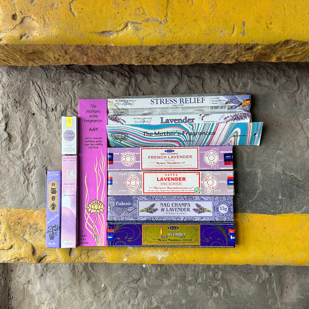 Collection of incense boxes on a stone surface with a yellow base